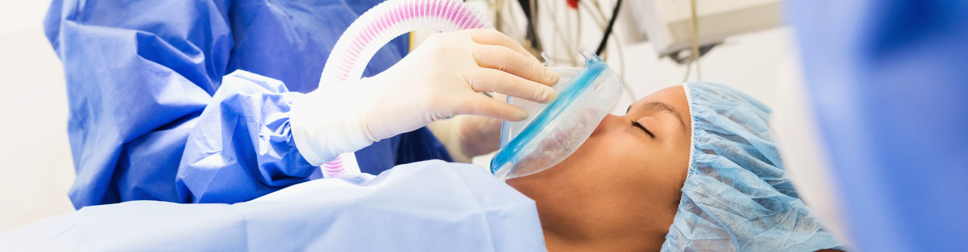 Dentist placing breathing mask on woman's face.
